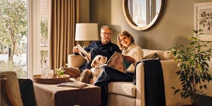 a man and woman sitting on a couch with a dog