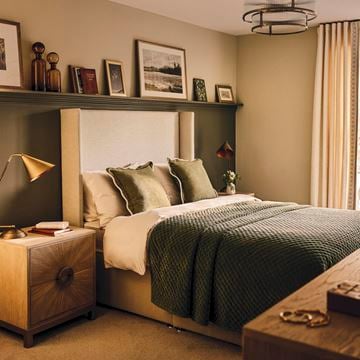 a bedroom with a bed and a shelf with pictures on it